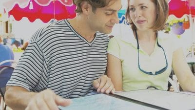 Store marketing during holiday events shows young couple looking at a menu. There's a colorful, festive-looking background.