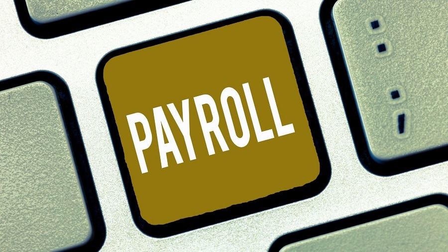 Minimum wage increase effects image shows closeup of keyboard. One key has gold background with white text "PAYROLL".
