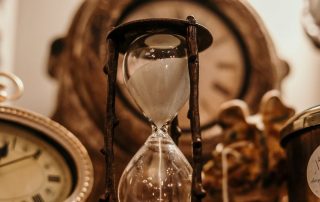 Limited time offer image shows an hour glass with the sand running thru it. It has a muted clock in the background and one on the left. The colors are tans & browns.