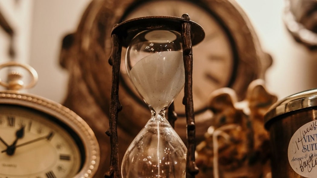 Limited time offer image shows an hour glass with the sand running thru it. It has a muted clock in the background and one on the left. The colors are tans & browns.