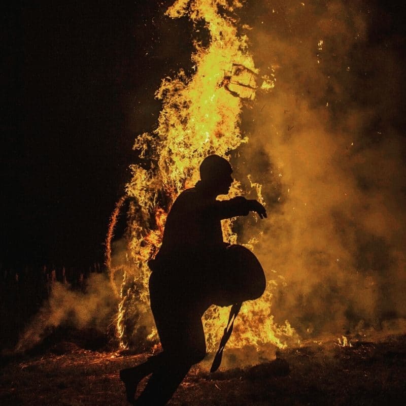 Unsubstantiated blame shame image shows a firefighter in front of a large flame. It is night time.